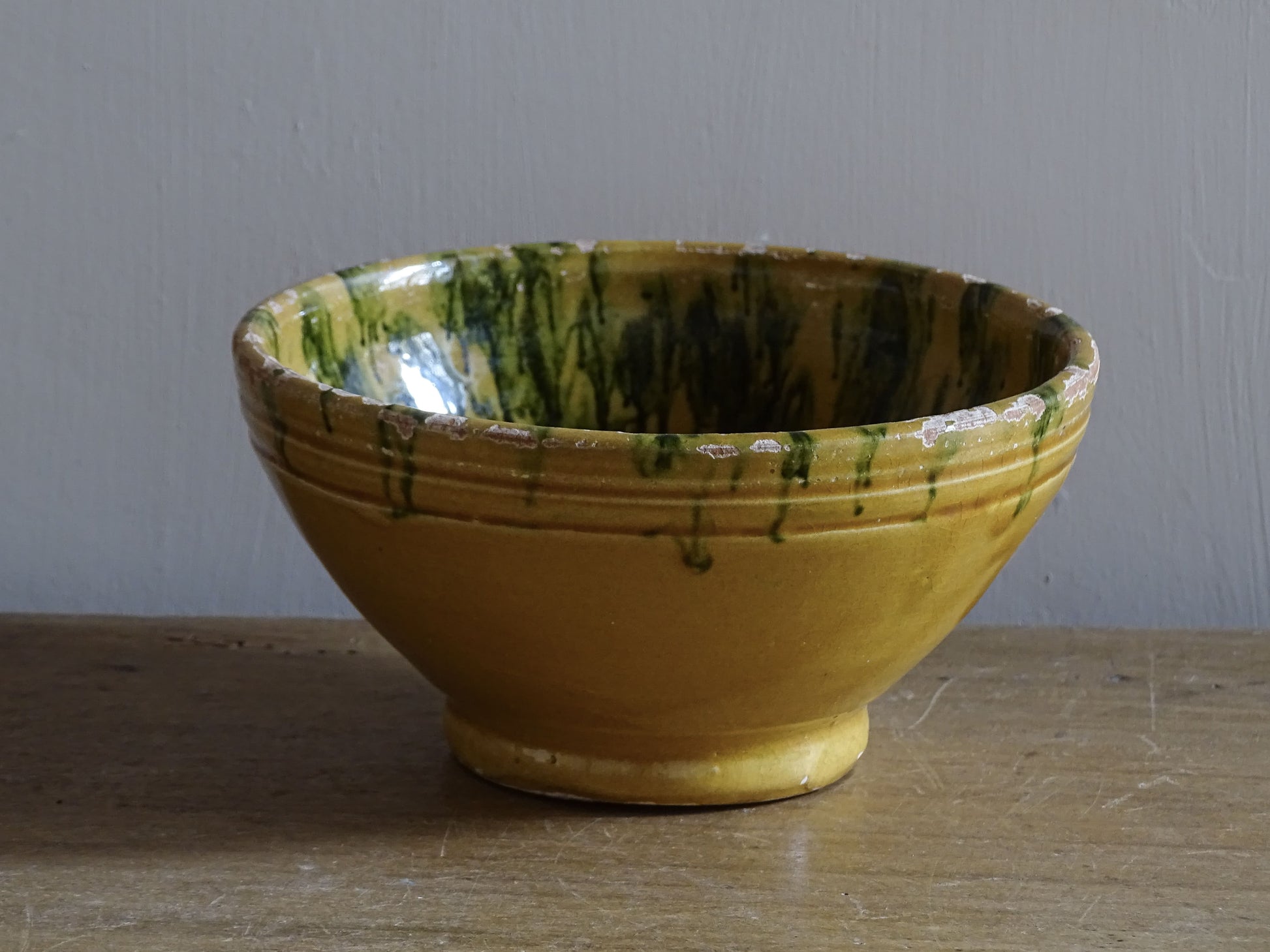  A small French antique terracotta bowl with a striking yellow ochre glaze and a traditional green jaspé decorated interior. Hand-thrown in earthenware.