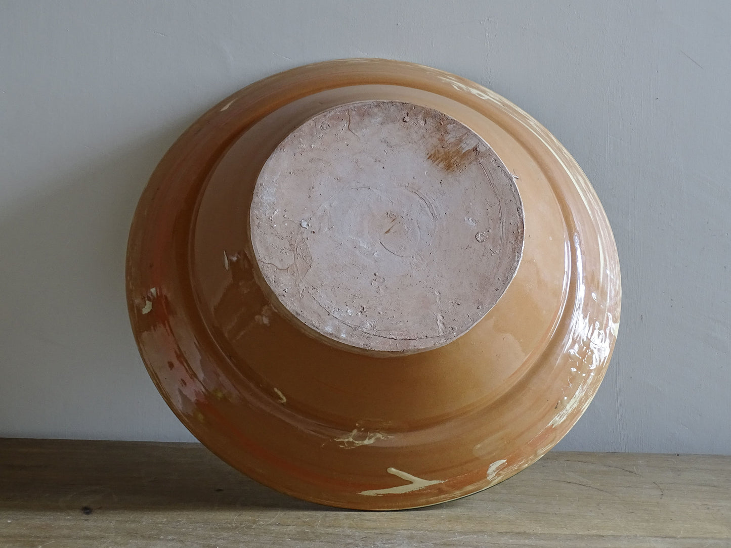   A large French  vintage  bowl  made from glazed terracotta with a warm honey-toned exterior, a soft cream glazed interior and a traditional green rim. 