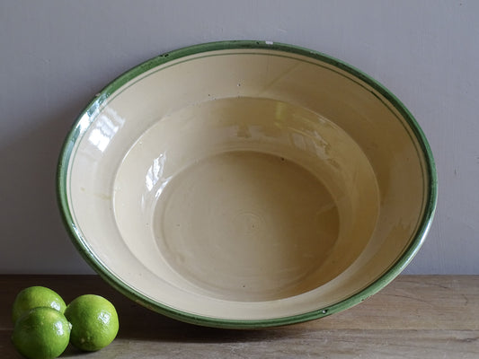   A large French  vintage  bowl  made from glazed terracotta with a warm honey-toned exterior, a soft cream glazed interior and a traditional green rim. 