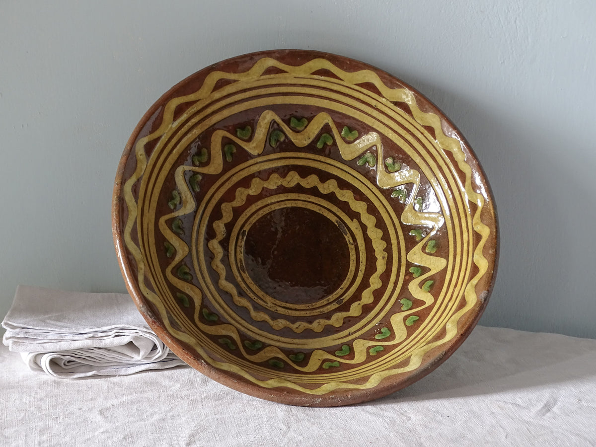 French antique earthenware bowl with orange glaze and geometric yellow pattern. 
