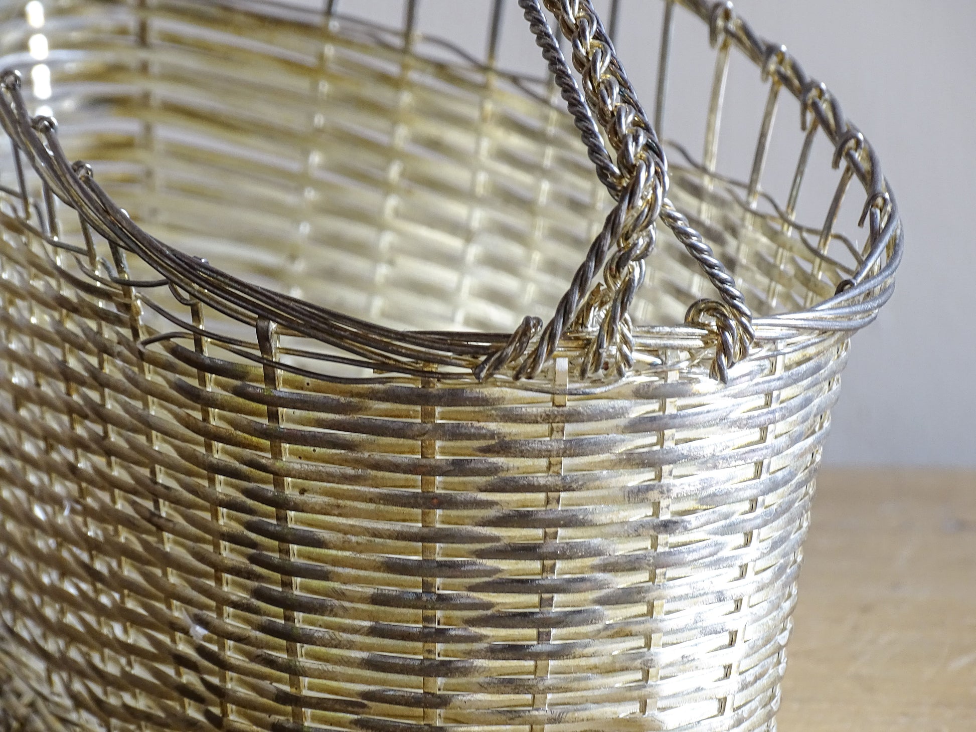 French vintage silver-tone wire wine basket or bottle carrier. It has a woven design and twisted carry handle.