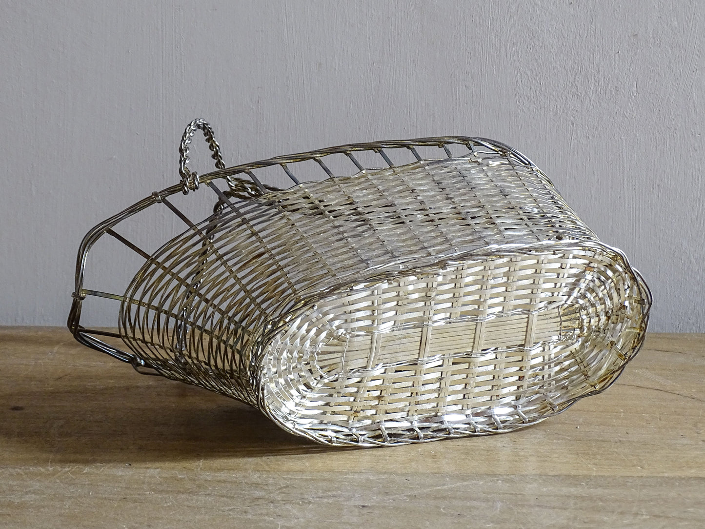French vintage silver-tone wire wine basket or bottle carrier. It has a woven design and twisted carry handle.