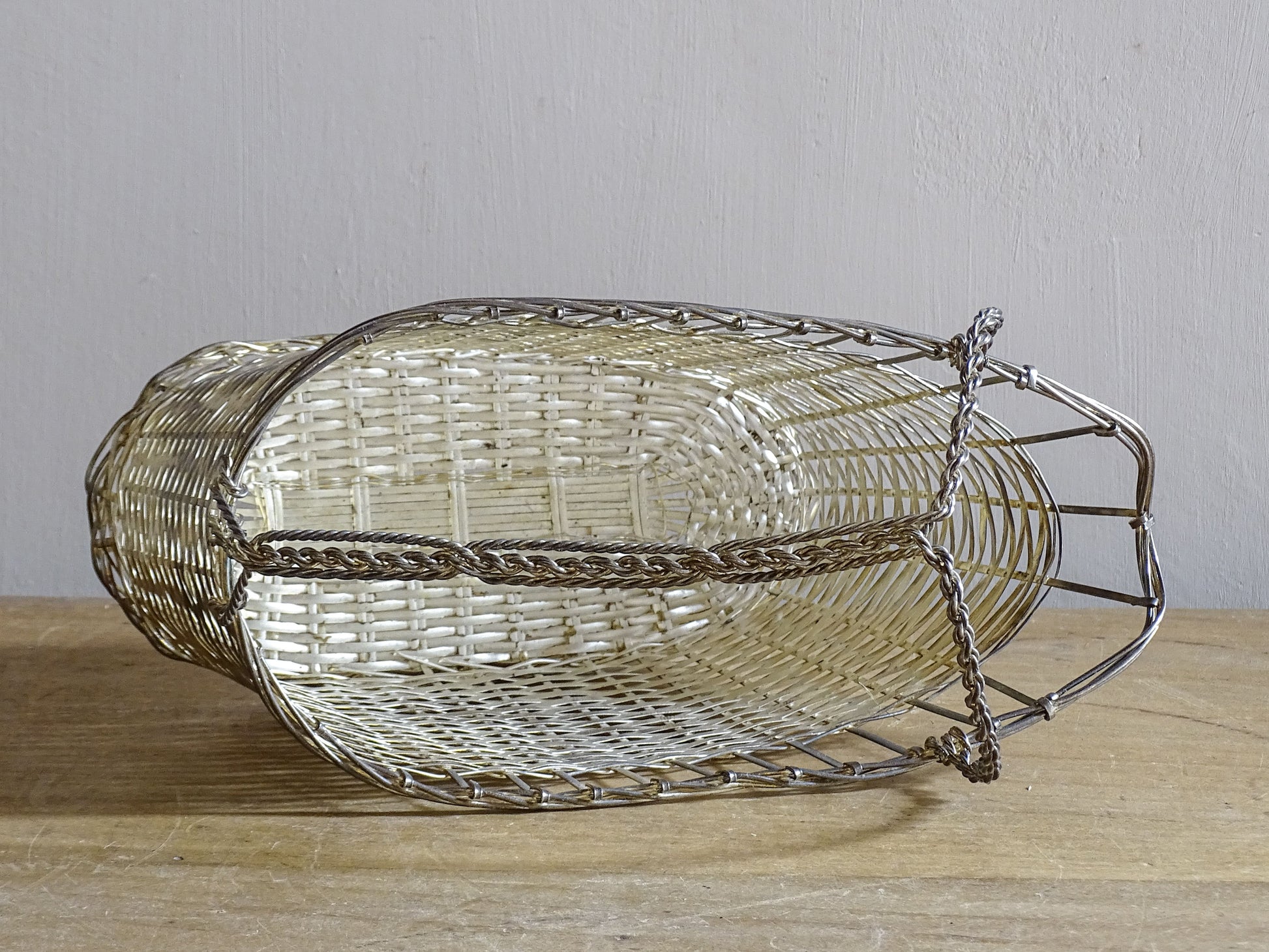 French vintage silver-tone wire wine basket or bottle carrier. It has a woven design and twisted carry handle.