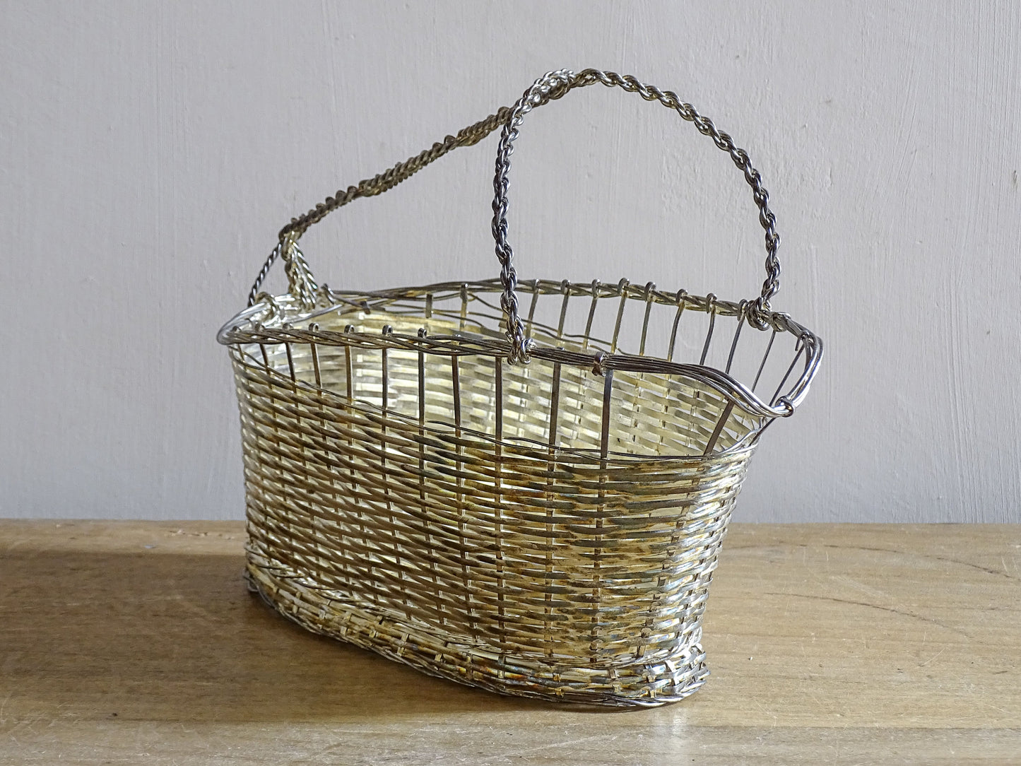 French vintage silver-tone wire wine basket or bottle carrier. It has a woven design and twisted carry handle.