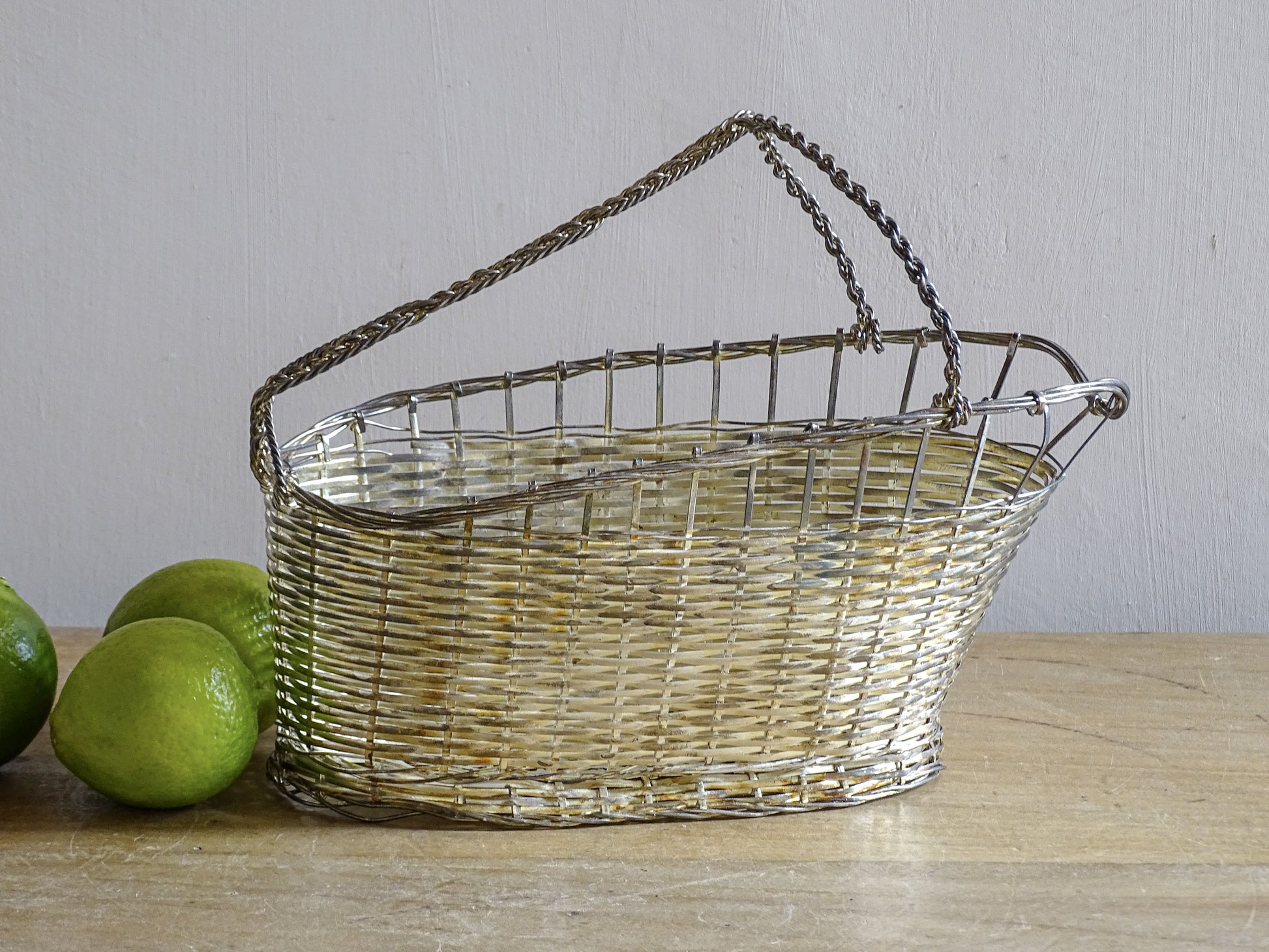 French vintage silver-tone wire wine basket or bottle carrier. It has a woven design and twisted carry handle.