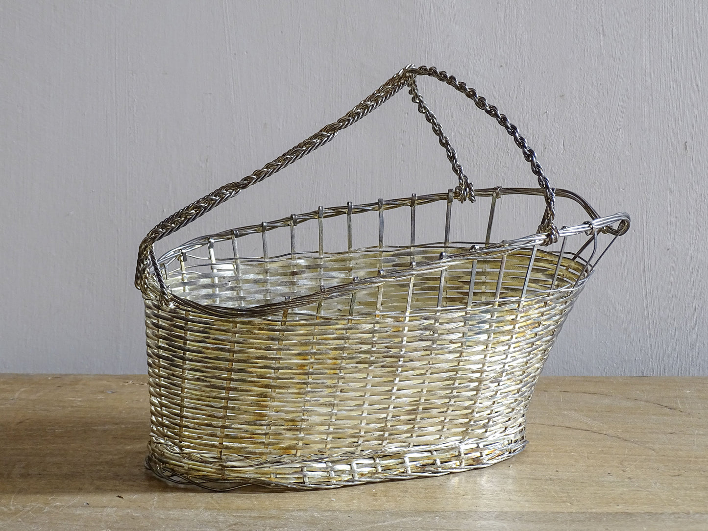 French vintage silver-tone wire wine basket or bottle carrier. It has a woven design and twisted carry handle.