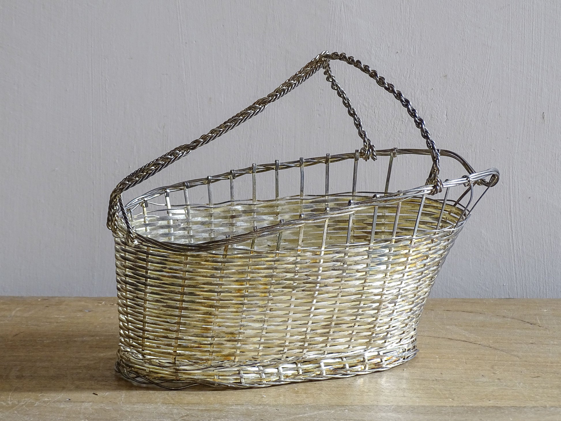 French vintage silver-tone wire wine basket or bottle carrier. It has a woven design and twisted carry handle.