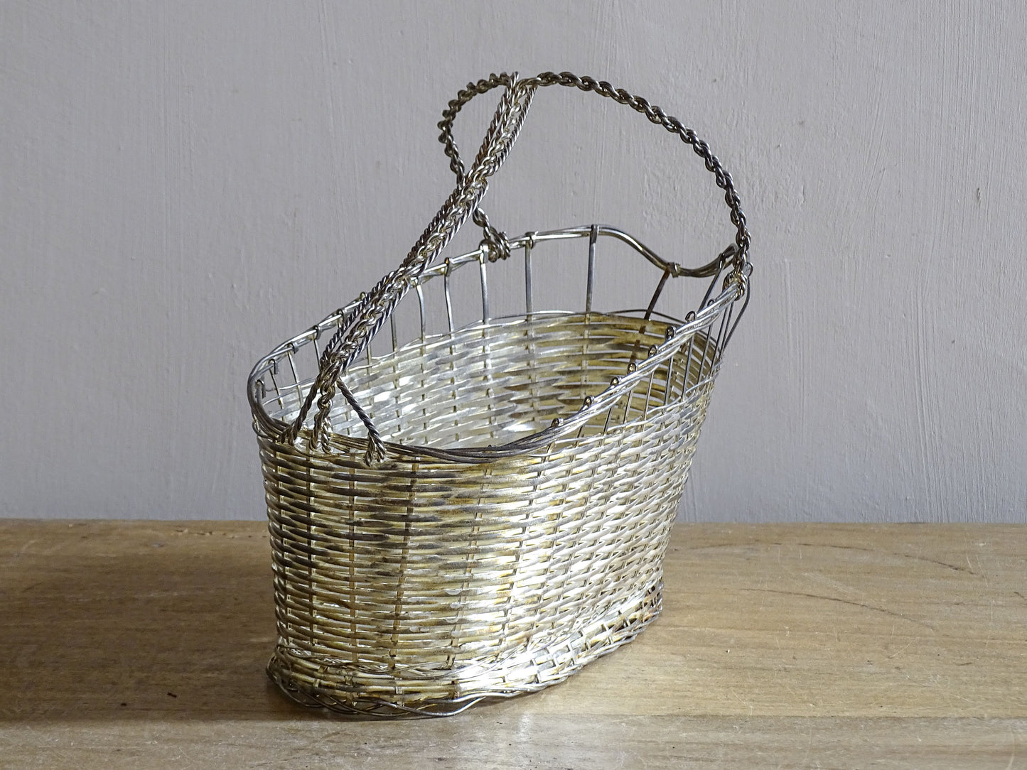 French vintage silver-tone wire wine basket or bottle carrier. It has a woven design and twisted carry handle.