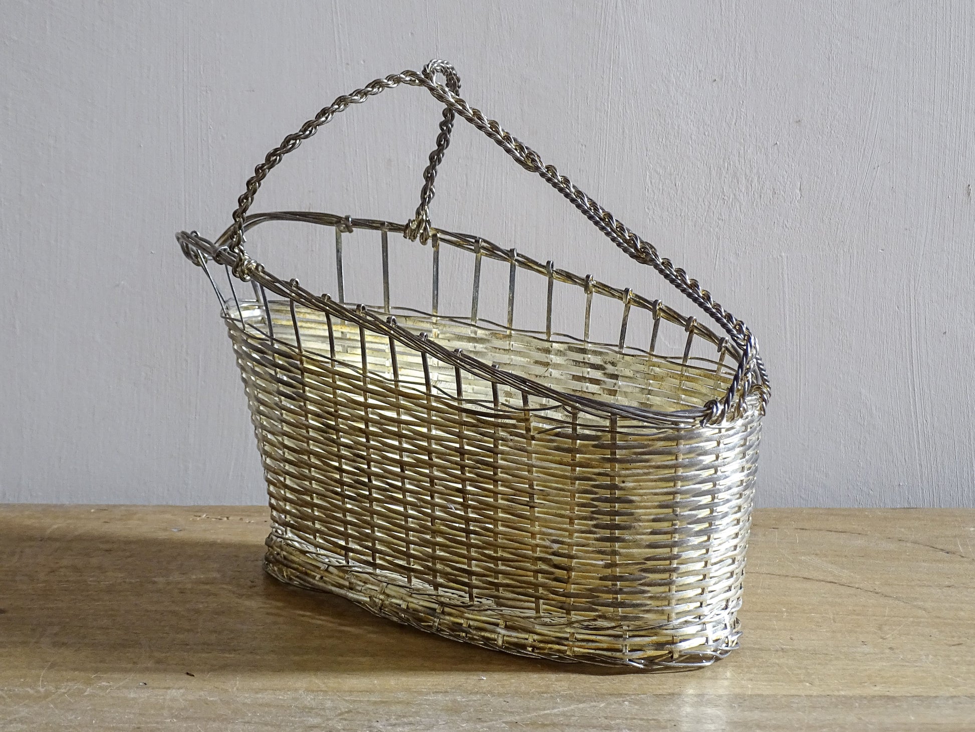French vintage silver-tone wire wine basket or bottle carrier. It has a woven design and twisted carry handle.