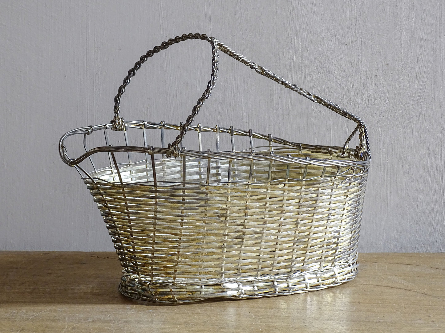 French vintage silver-tone wire wine basket or bottle carrier. It has a woven design and twisted carry handle.