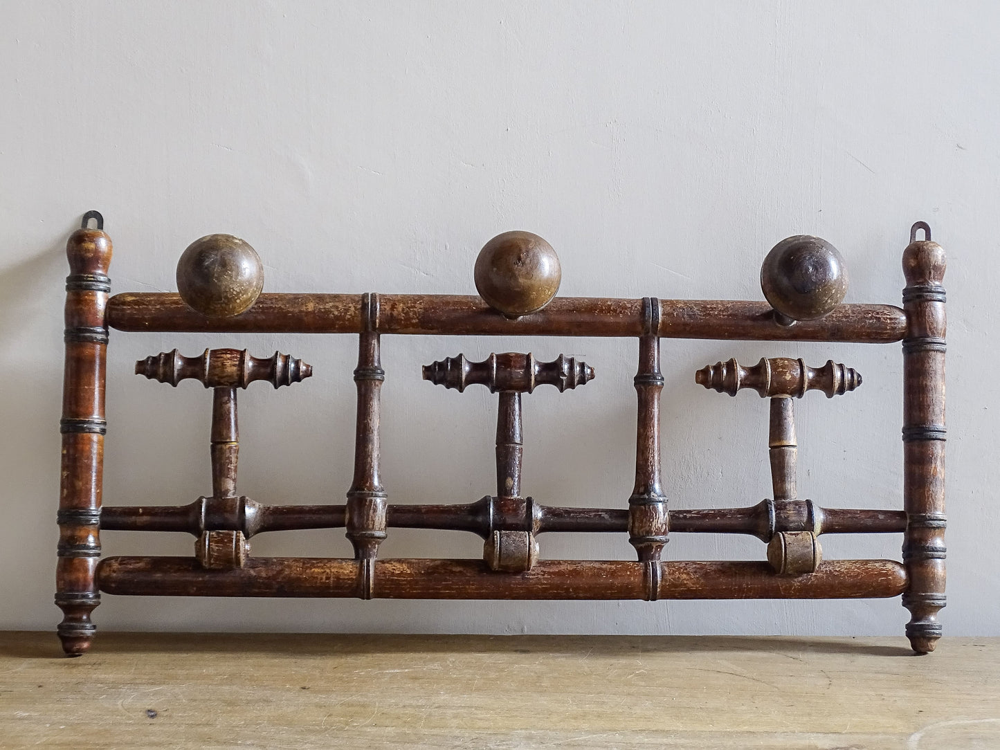 French antique faux bamboo wooden coat hook rack with turned pegs, warm patina and rustic wear. A decorative wall rack for hallway, bedroom or boot room.