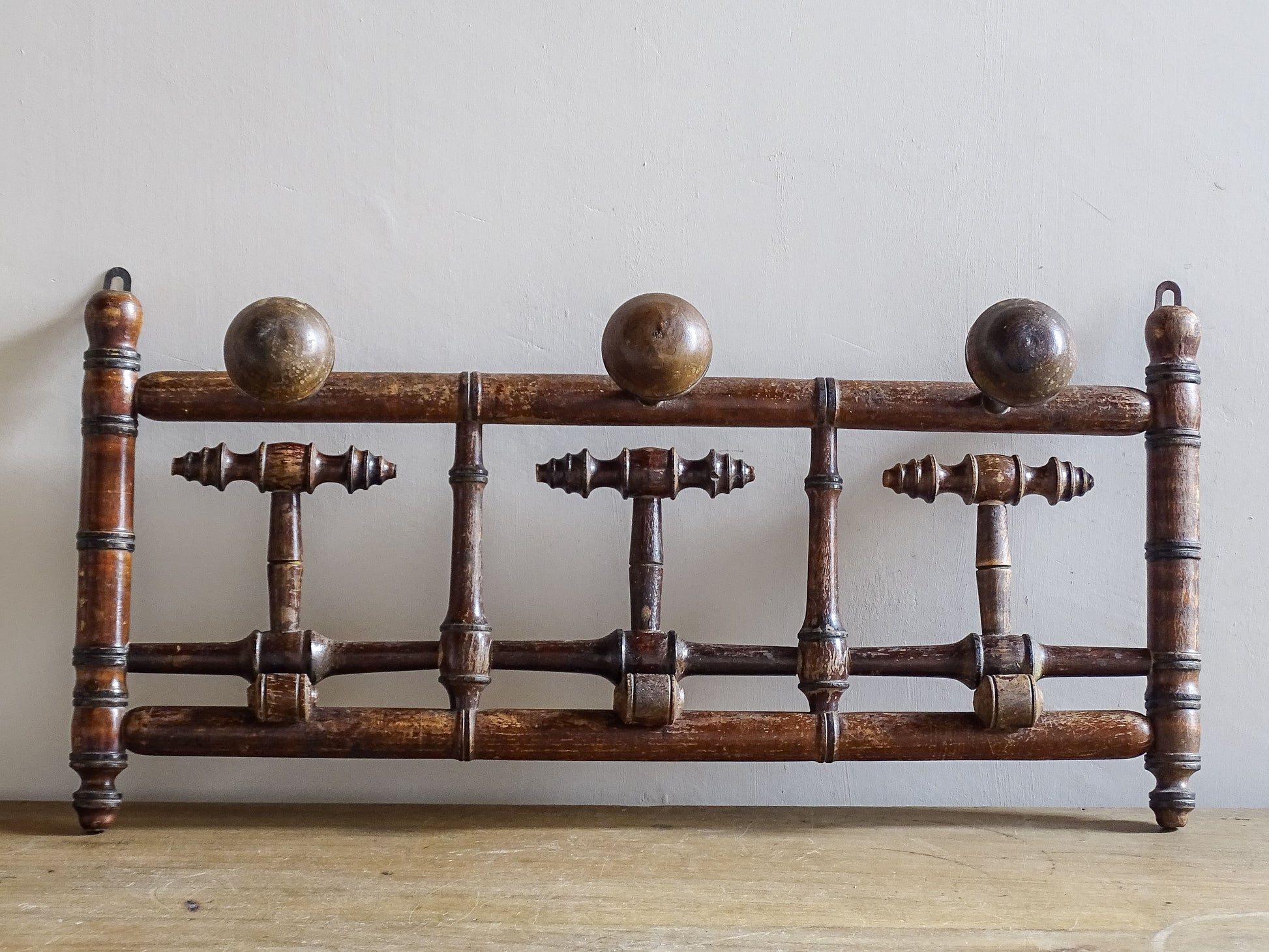 French antique faux bamboo wooden coat hook rack with turned pegs, warm patina and rustic wear. A decorative wall rack for hallway, bedroom or boot room.