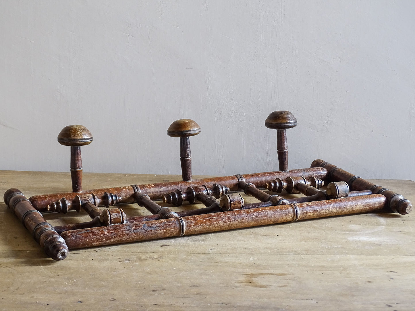 French antique faux bamboo wooden coat hook rack with turned pegs, warm patina and rustic wear. A decorative wall rack for hallway, bedroom or boot room.