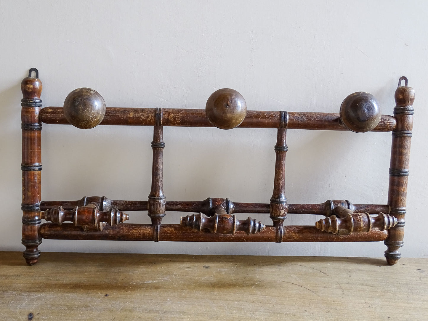 French antique faux bamboo wooden coat hook rack with turned pegs, warm patina and rustic wear. A decorative wall rack for hallway, bedroom or boot room.