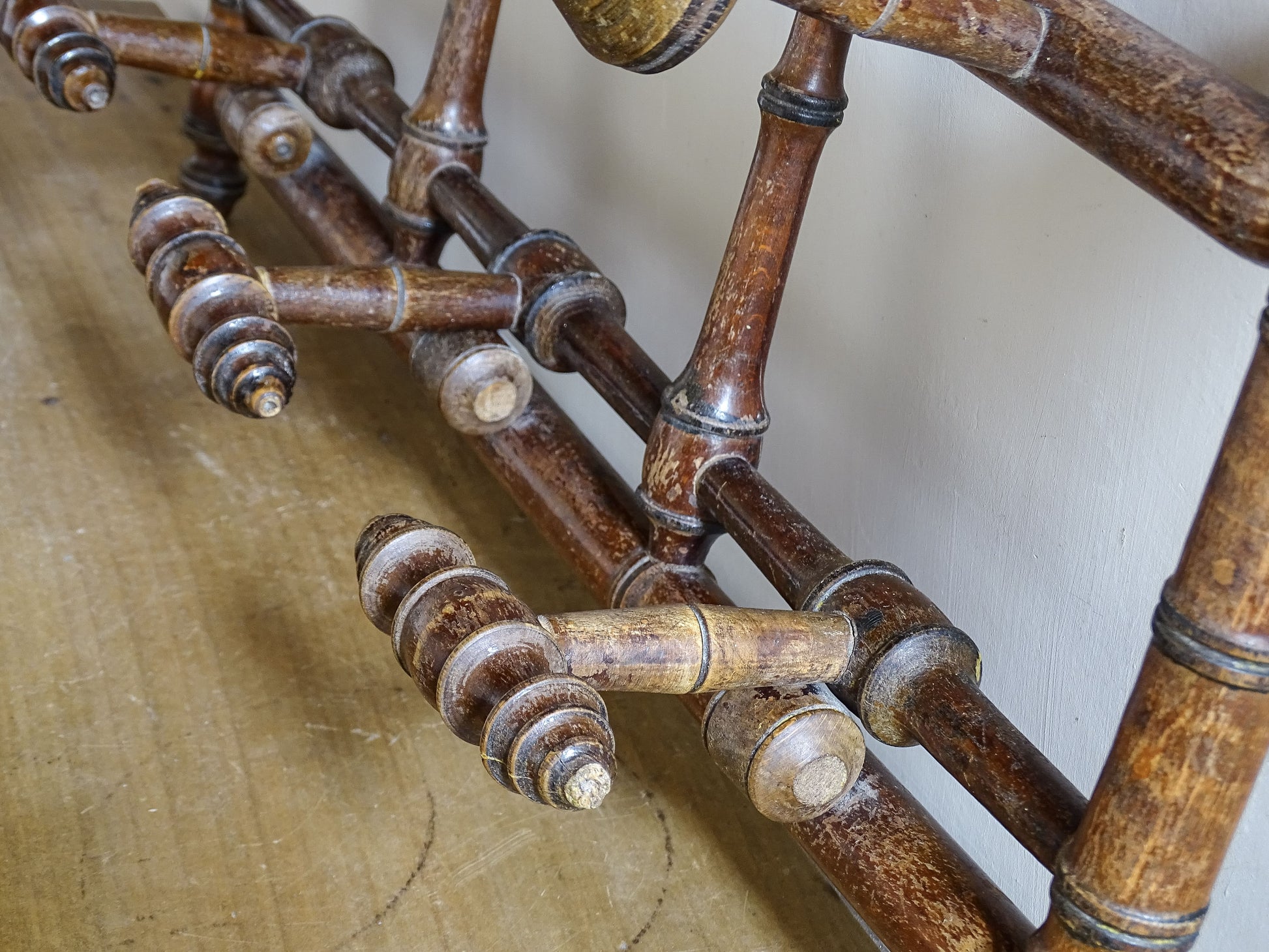 French antique faux bamboo wooden coat hook rack with turned pegs, warm patina and rustic wear. A decorative wall rack for hallway, bedroom or boot room.