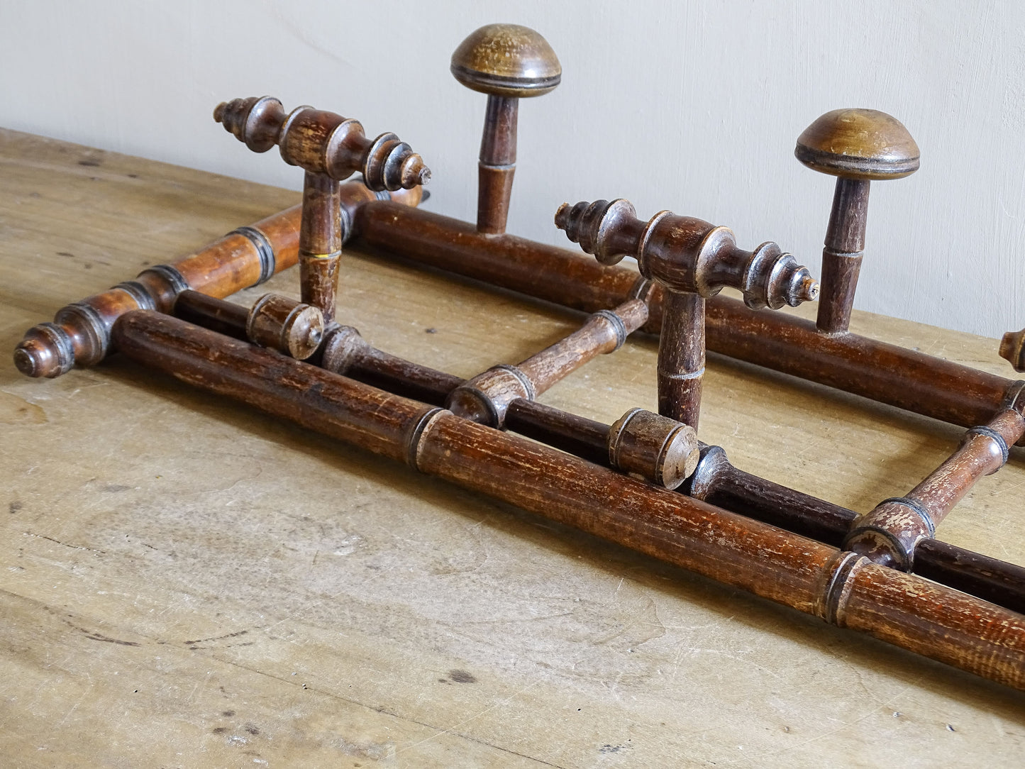French antique faux bamboo wooden coat hook rack with turned pegs, warm patina and rustic wear. A decorative wall rack for hallway, bedroom or boot room.