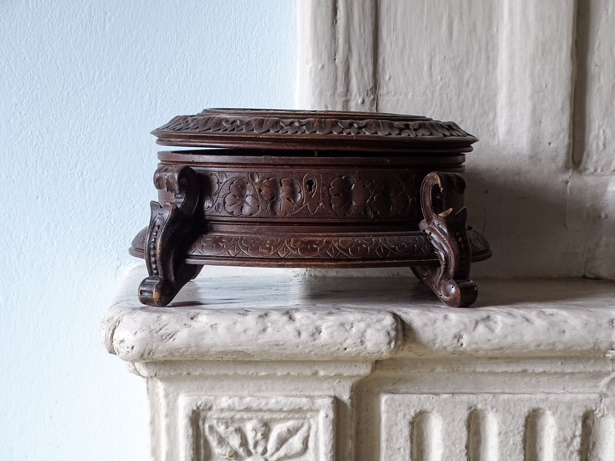 Swiss antique black forest wood box, displayed on a country house fireplace