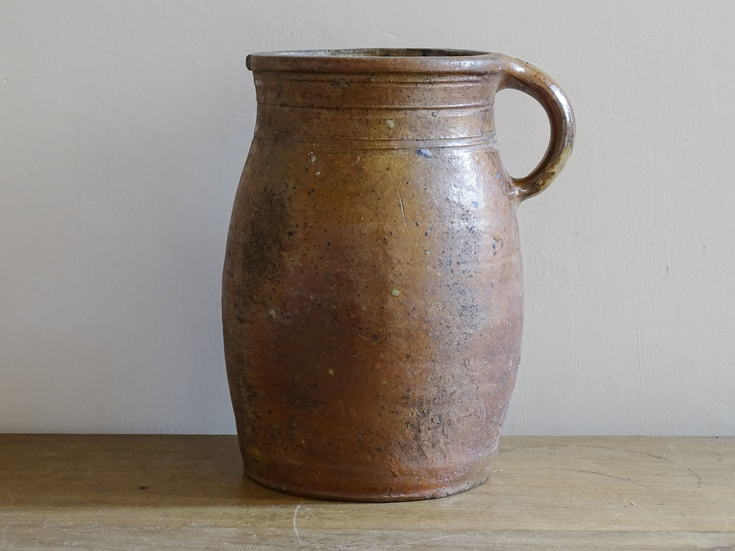 Rustic antique French pottery vessel on wooden table