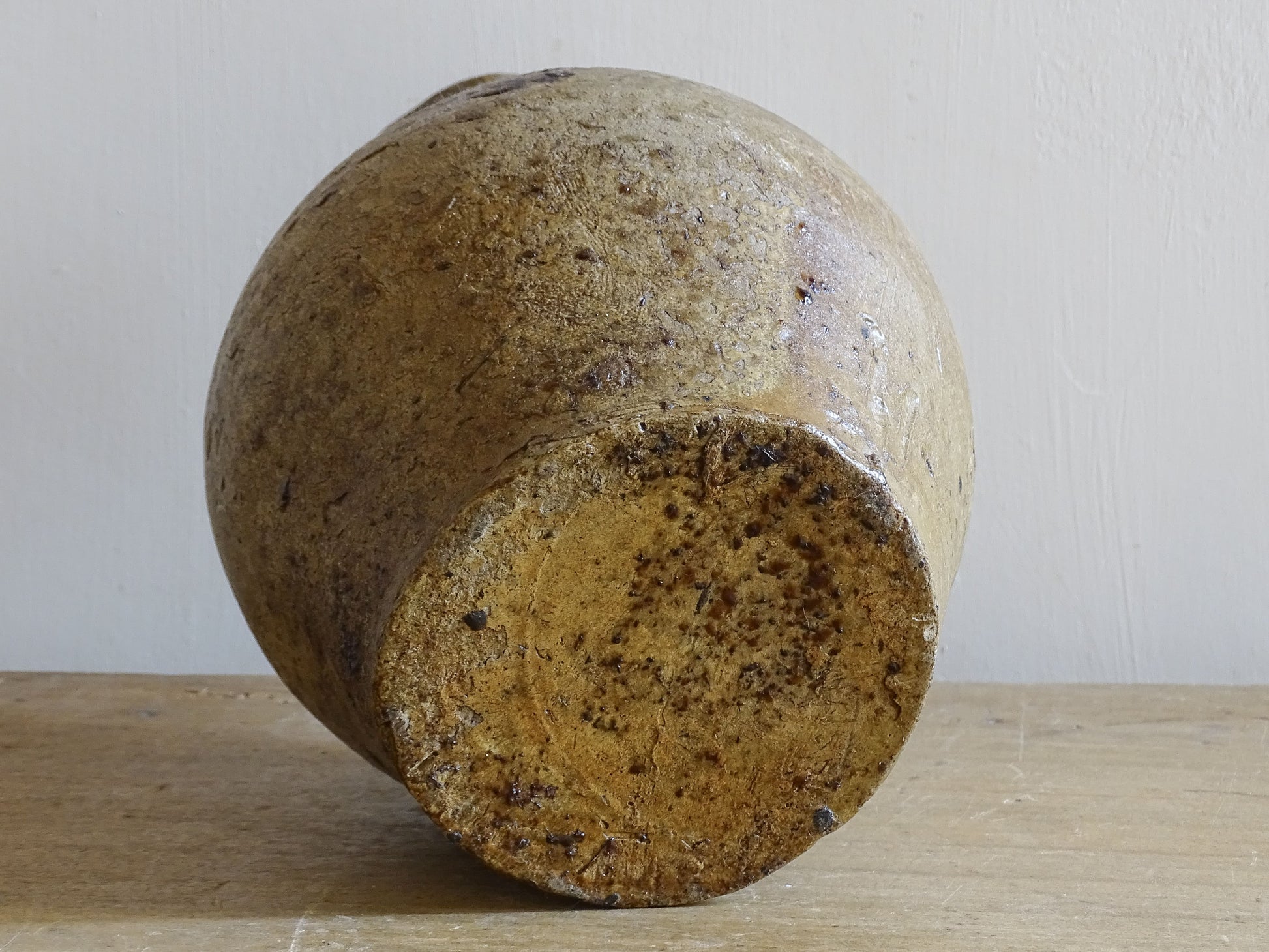 Antique French pottery cruche styled on rustic wooden surface with limes
