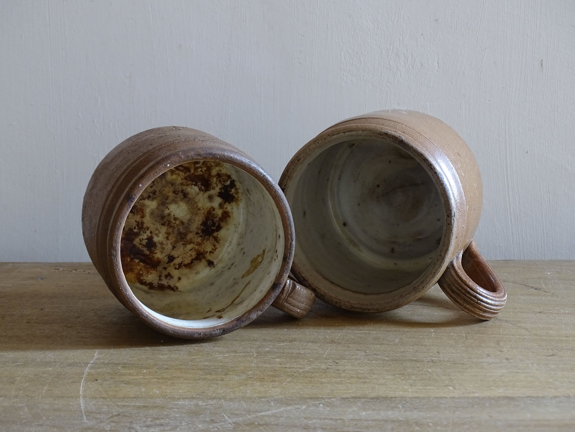Close up of vintage French stoneware mugs showing varied glaze and pottery texture