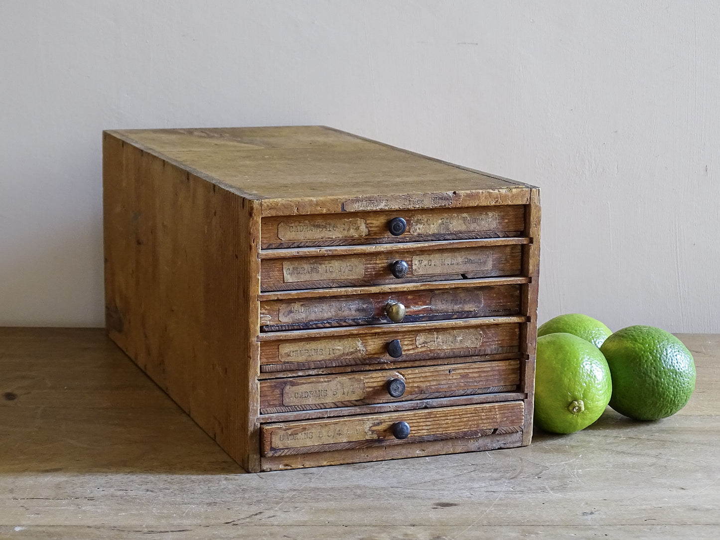 French antique watchmaker’s cabinet with six labelled drawers on rustic wooden table