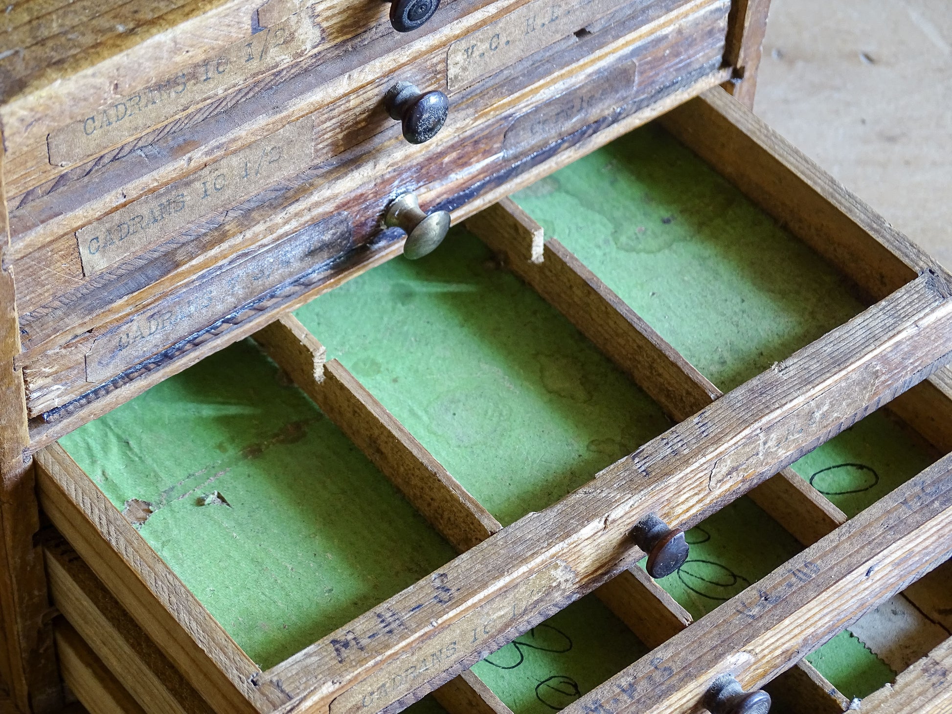 Decorative antique watchmaker’s cabinet styled on wooden tabletop 