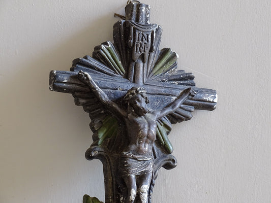 Antique religious wall decor featuring crucifix and holy water font