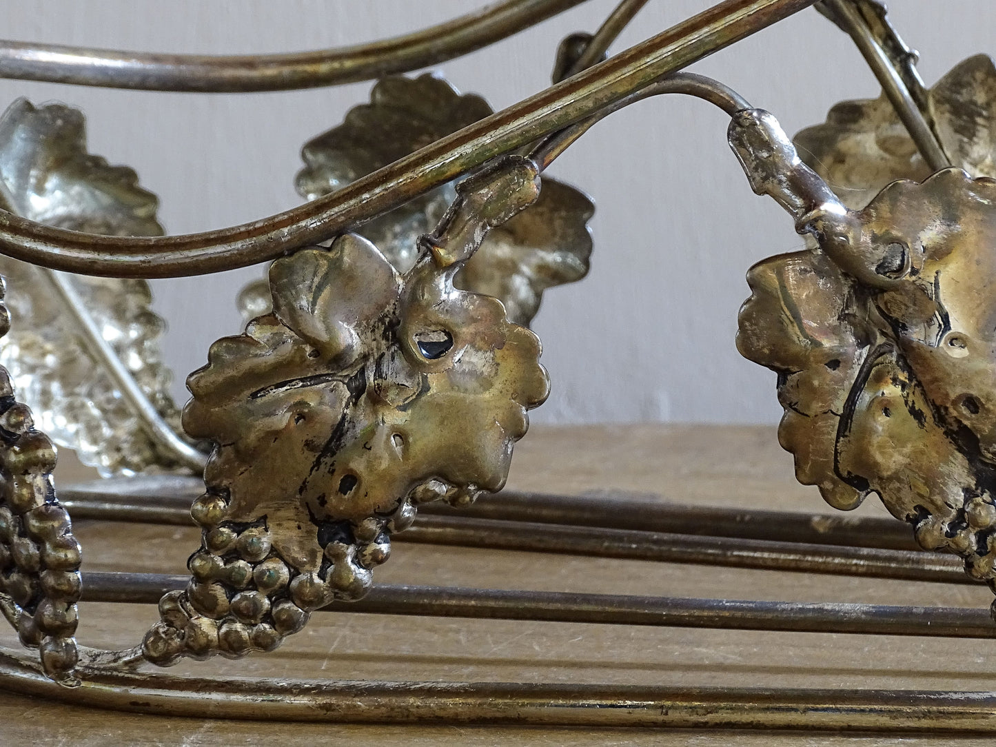 Decorative vineyard style wine bottle carrier with repoussé grape leaf details