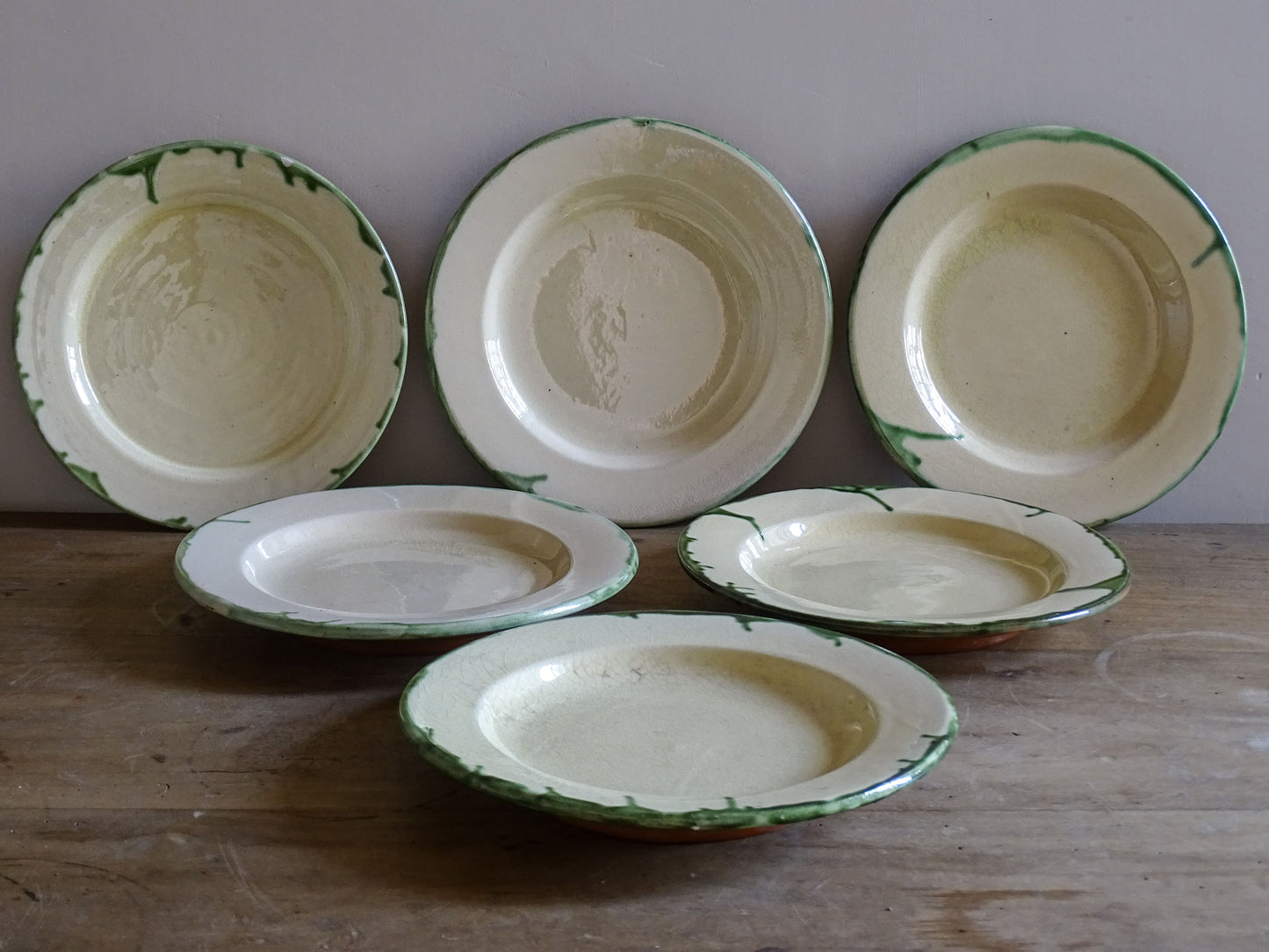 Vintage French country pottery plates stacked on wooden table