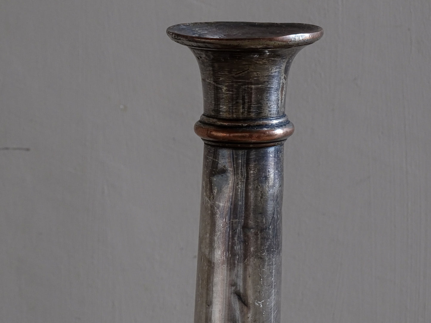 Pair of late 19th century French candlesticks in silver plate over copper with worn patina