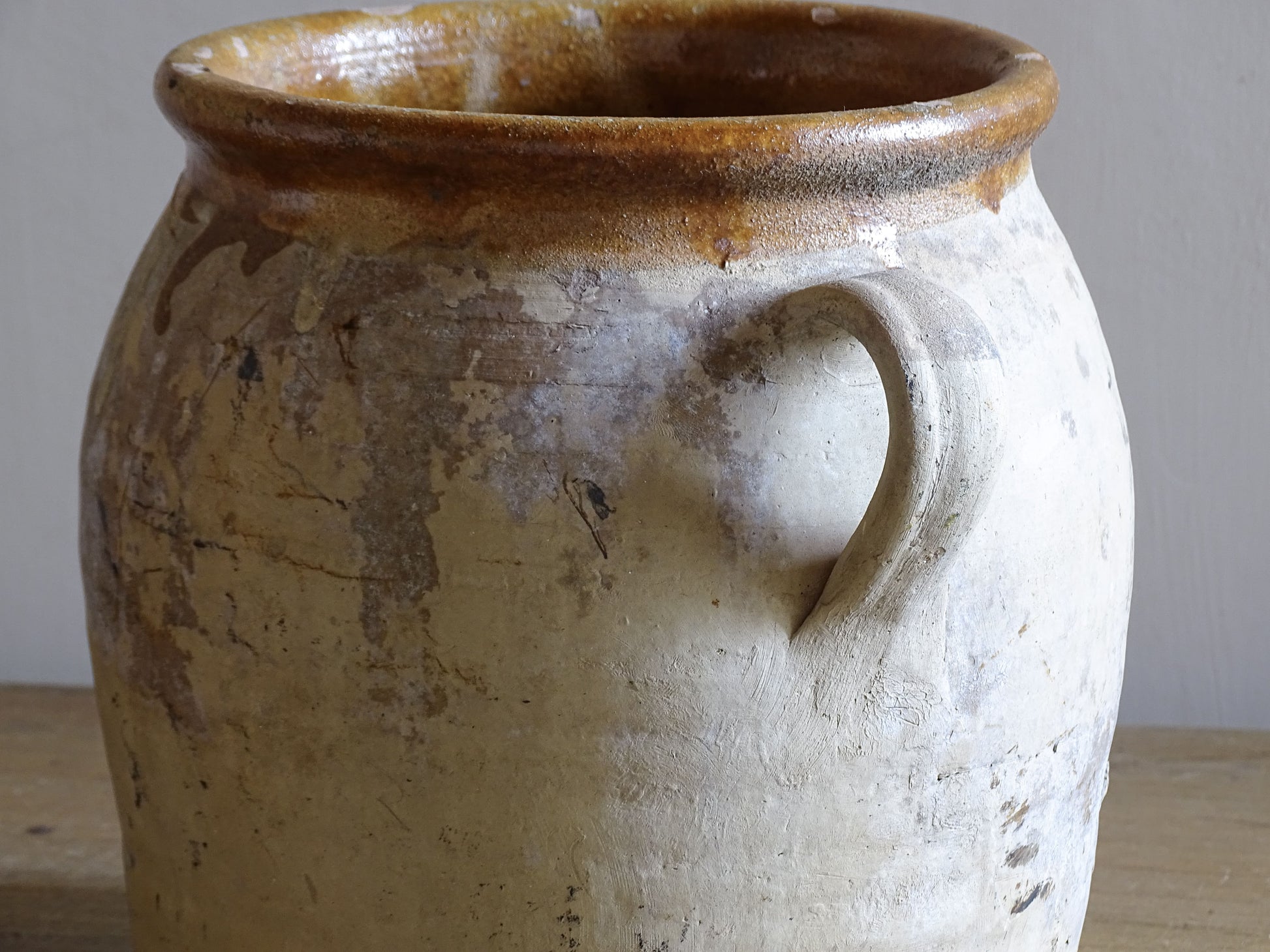 Rustic French pottery confit pot with twin handles and caramel glaze rim