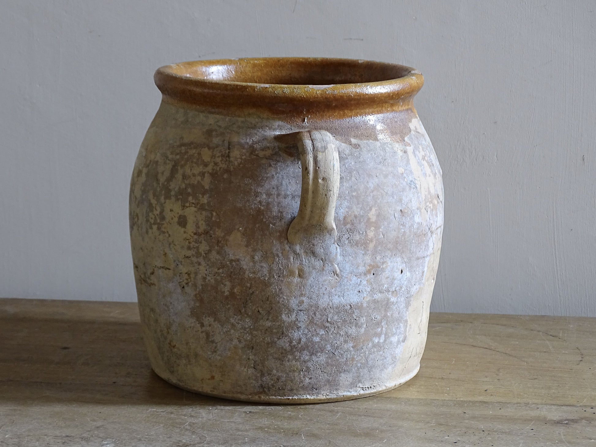 Decorative vintage French pottery pot with traditional twin handles and aged finish