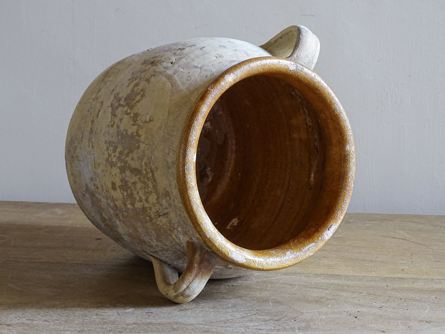 French country ceramic confit pot with creamy weathered surface and brown glaze rim