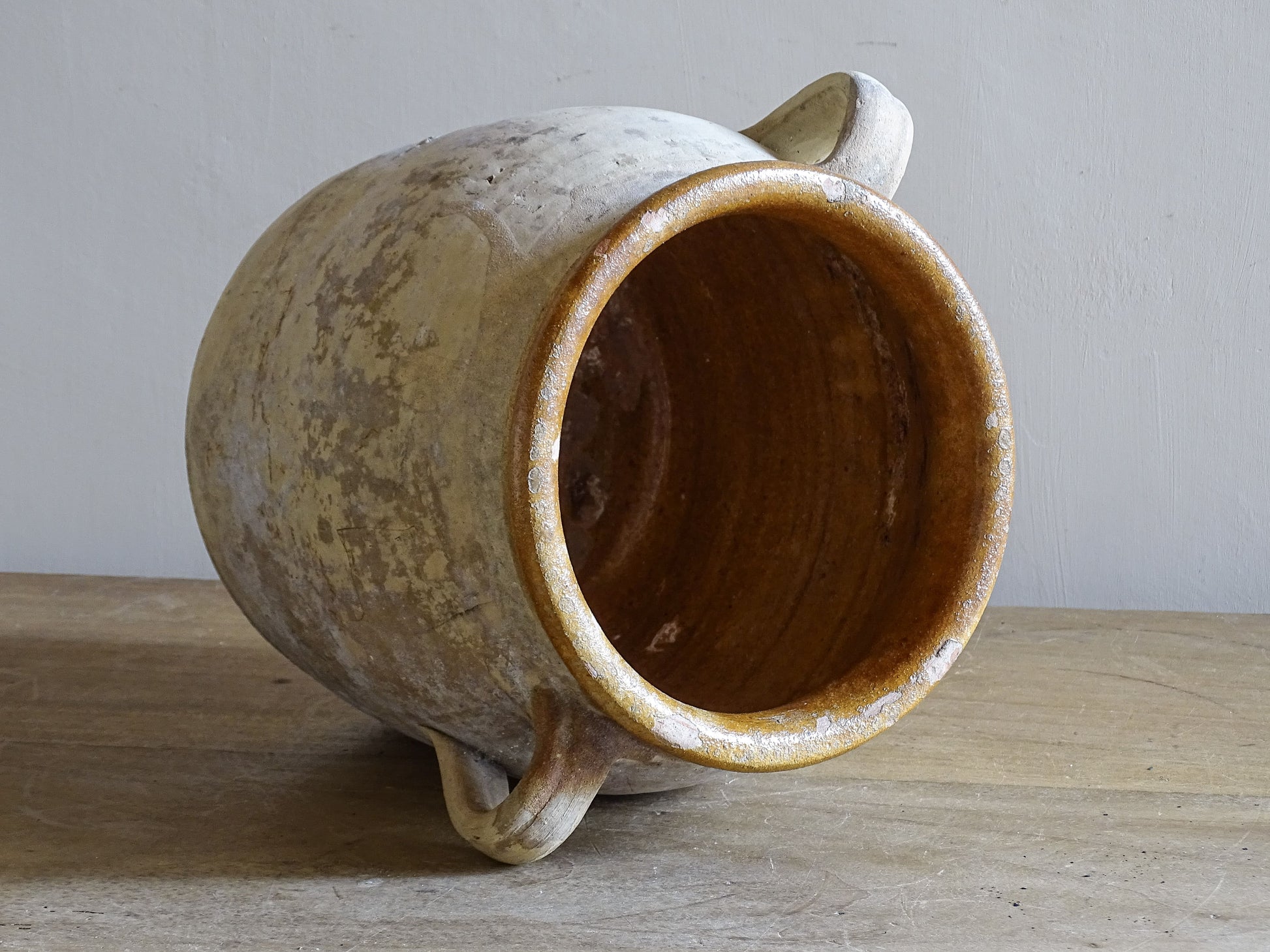 French country ceramic confit pot with creamy weathered surface and brown glaze rim