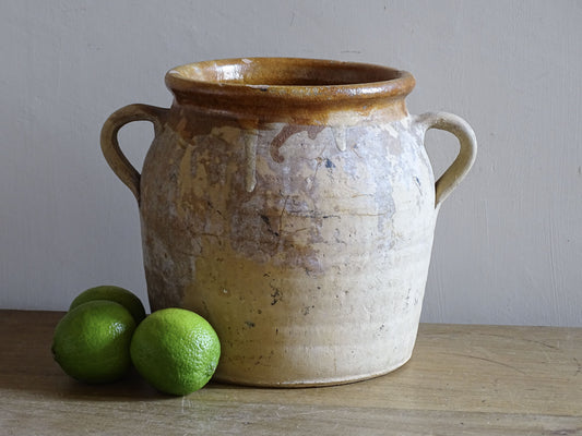 Vintage French ceramic confit pot with honey yellow glazed interior and worn cream exterior