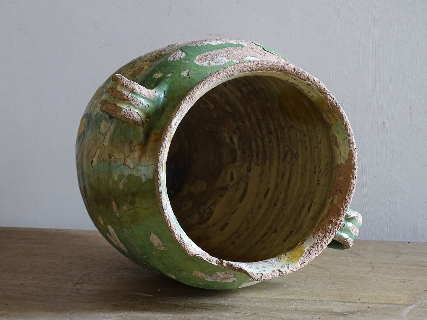 Antique French glazed pottery vessel with crackled green surface and rustic character