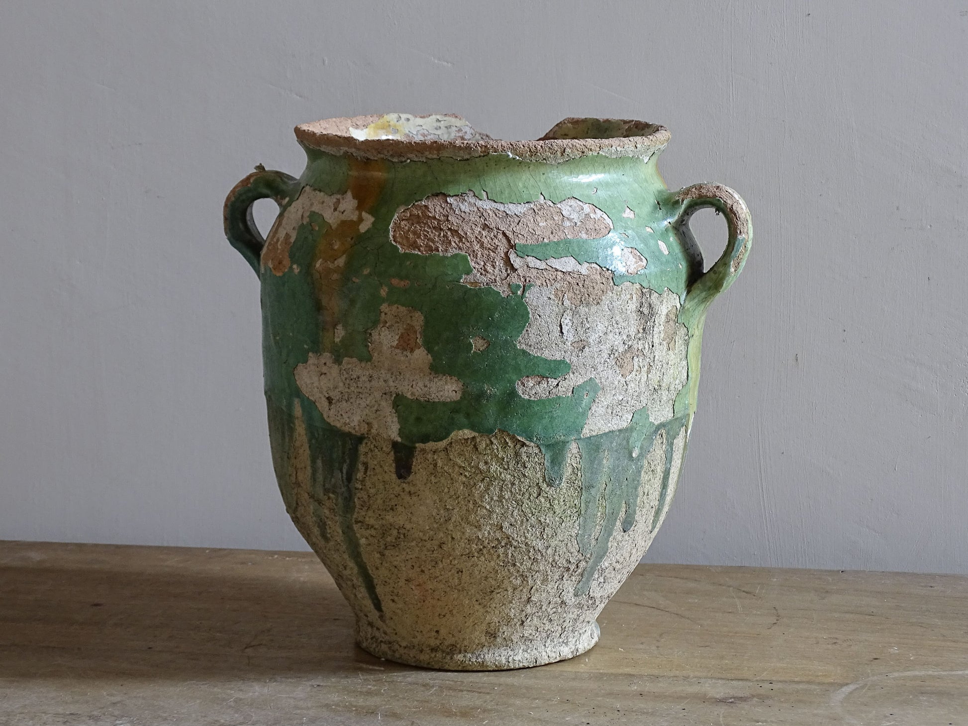 Rustic French pottery confit pot with aged green  and yellow glaze and exposed terracotta clay