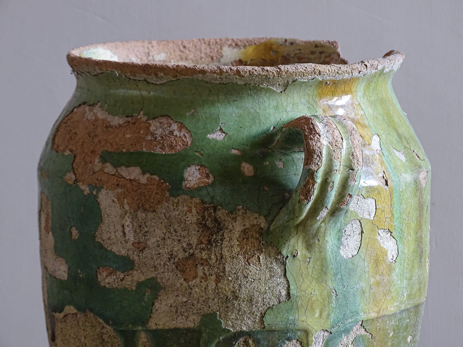 Timeworn French country pottery pot with two handles and textured glaze loss