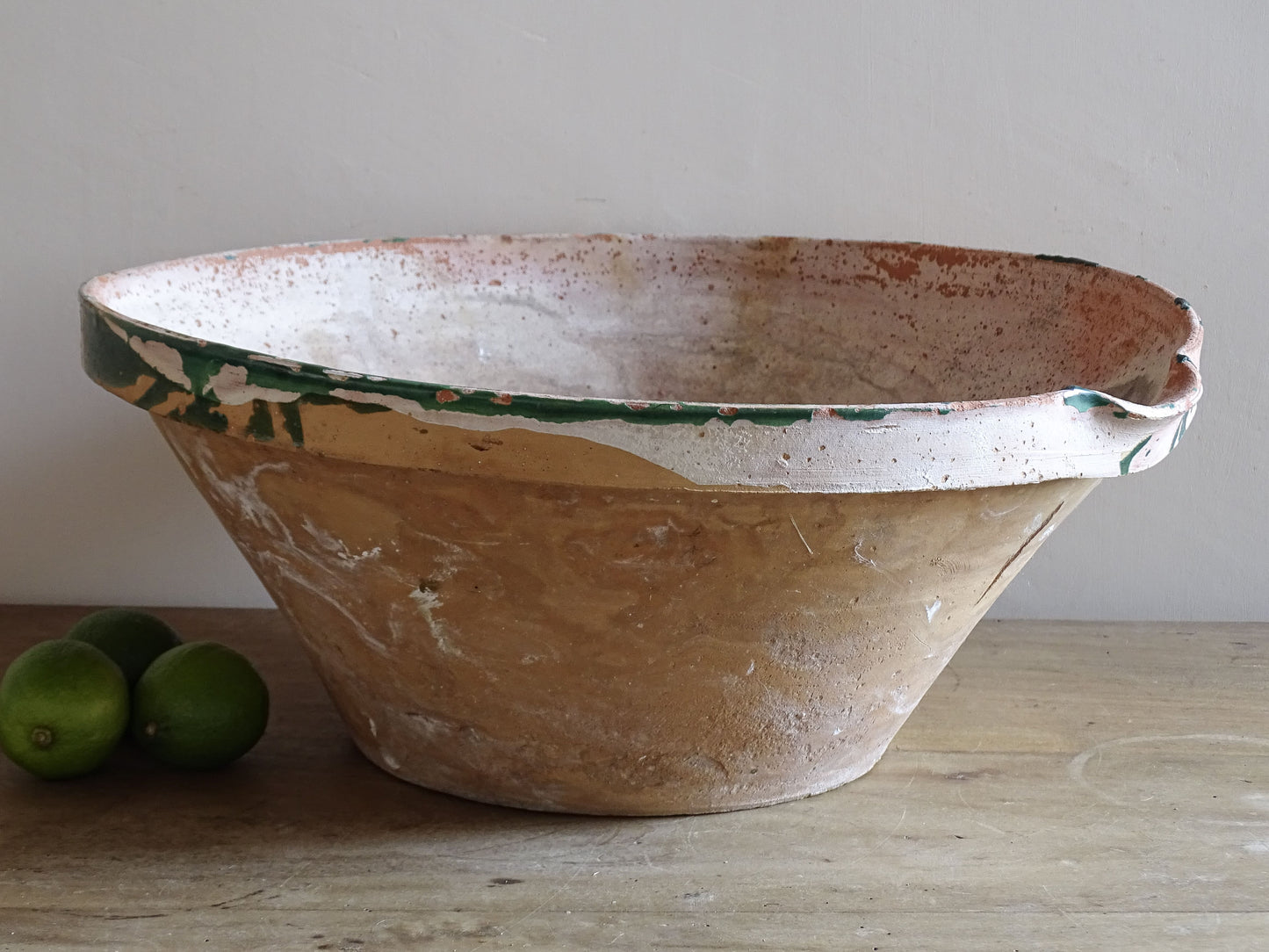 Large antique French tian bowl with worn green glaze and rustic terracotta surface