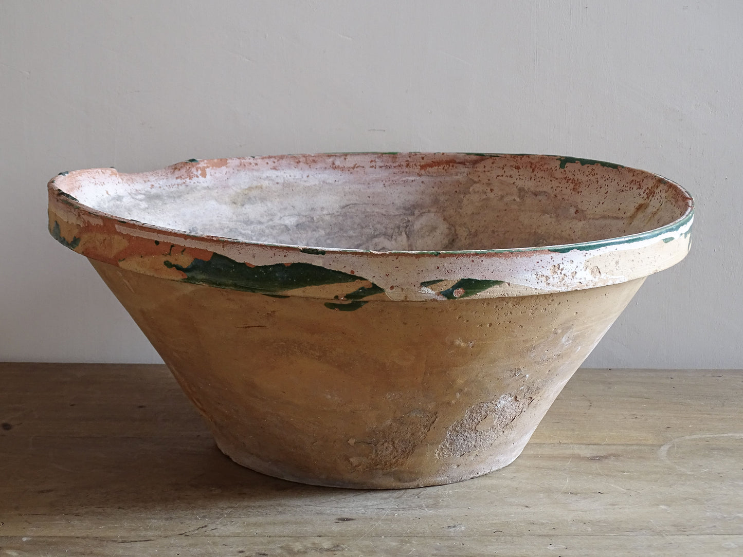 Large antique French earthenware bowl with flared shape and green glaze