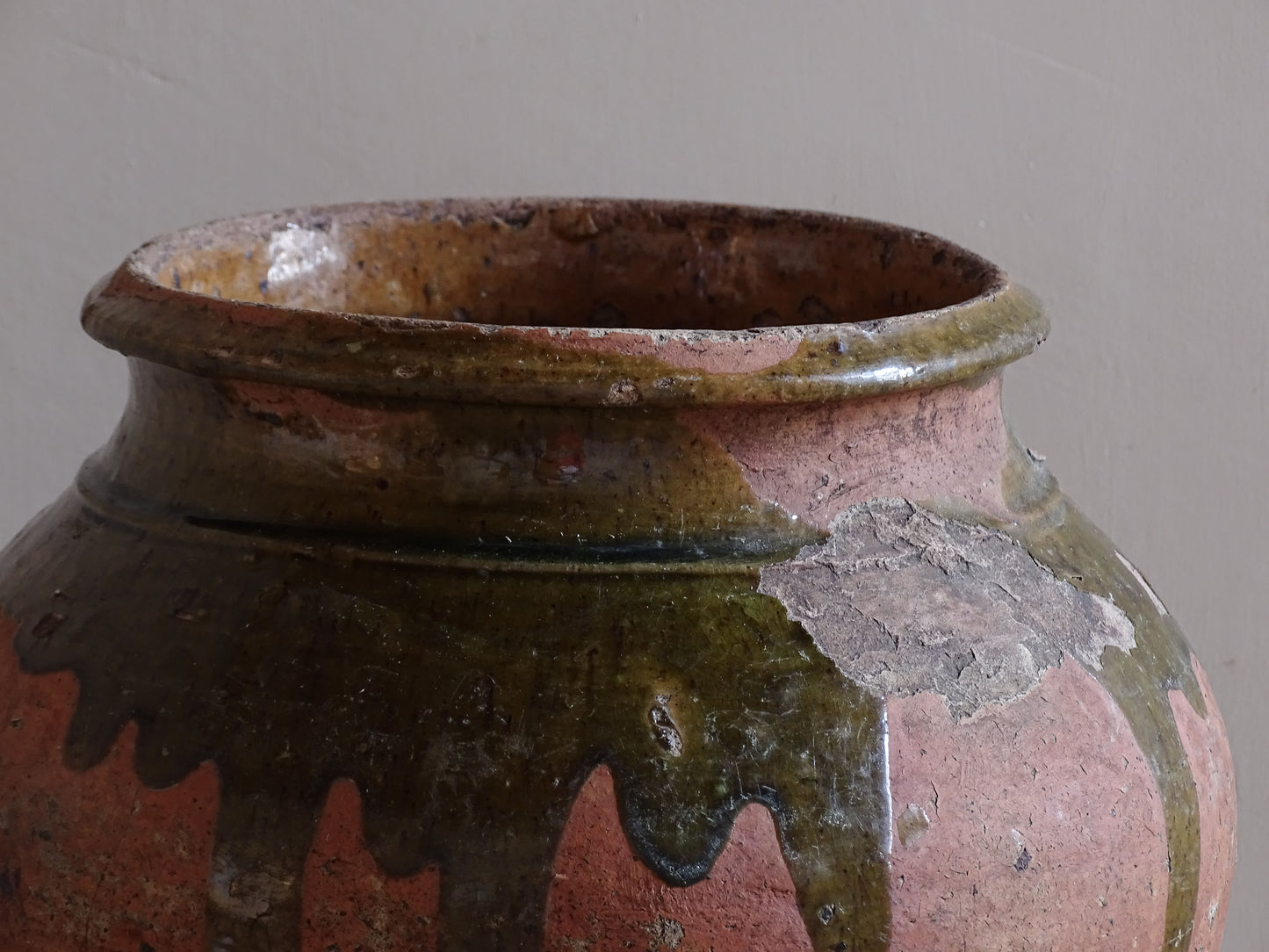 Rustic French pottery vessel with olive green drip glaze and mustard yellow interior