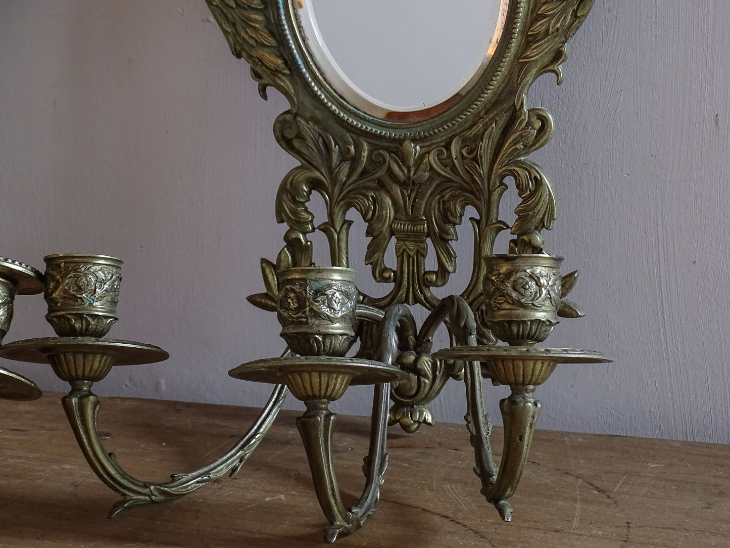Antique Napoleon III gilt brass mirrored wall sconce with decorative candle cups and drip trays.