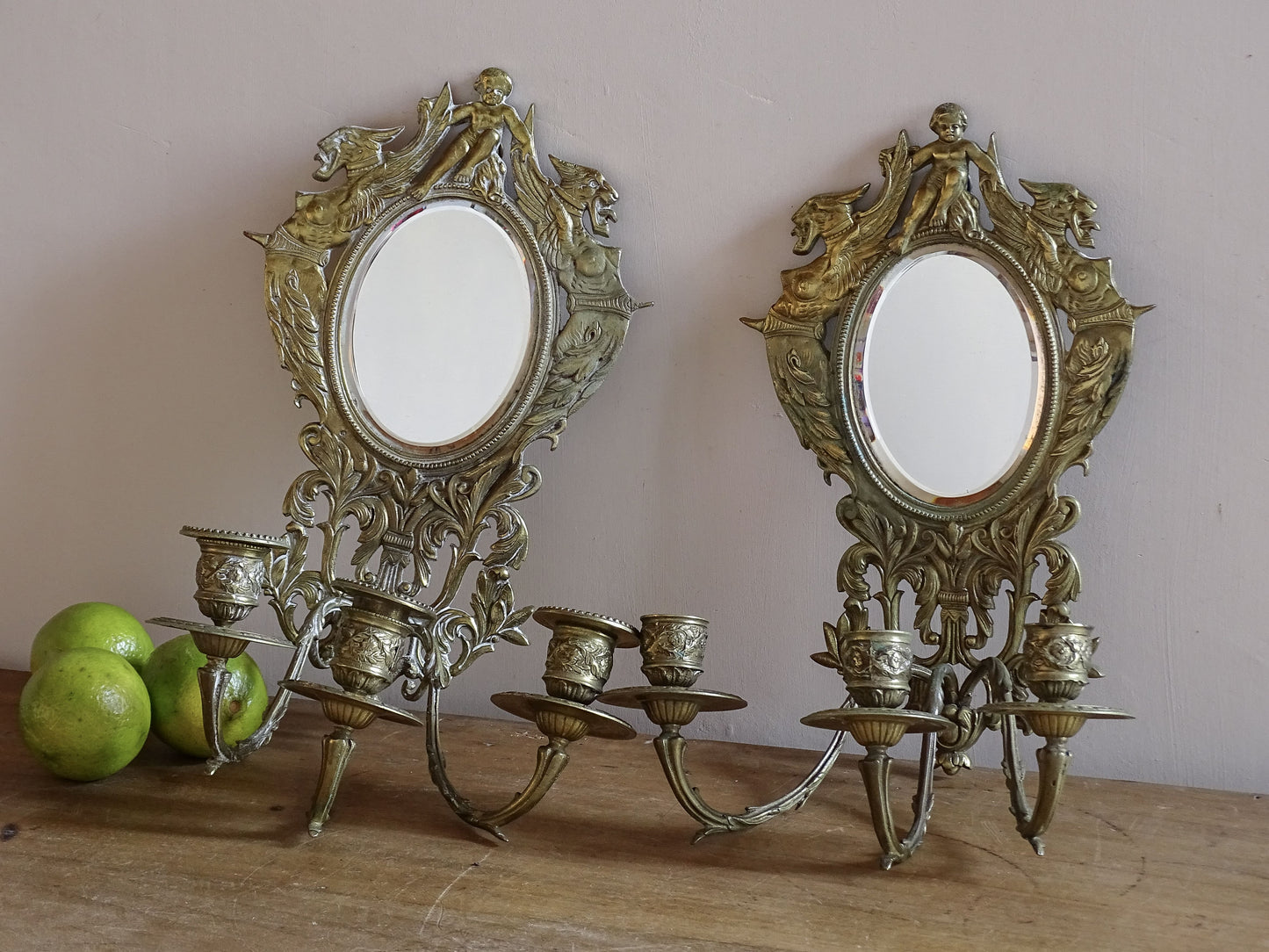 Pair of French antique mirror wall sconces with griffins and cherub in gilt brass, Napoleon III period.
