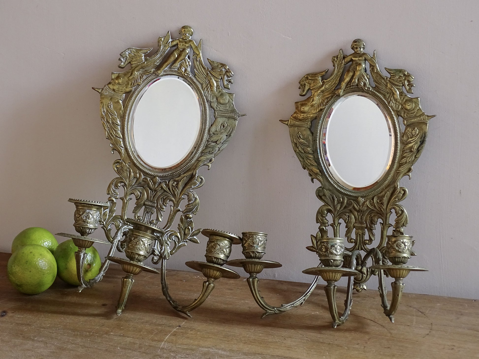 Pair of French antique mirror wall sconces with griffins and cherub in gilt brass, Napoleon III period.