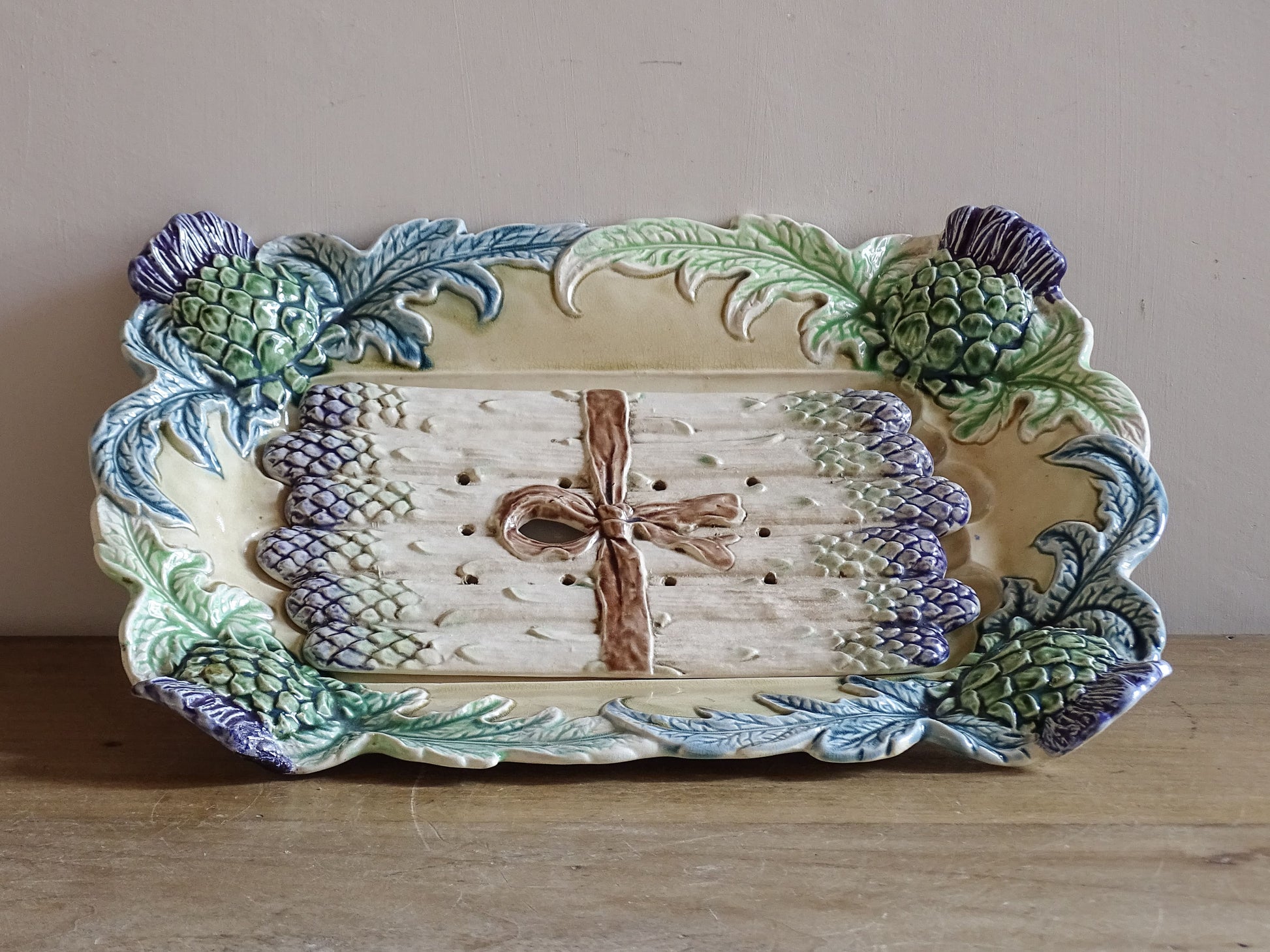 French majolica asparagus server featuring moulded artichokes, foliage and original perforated drainer.