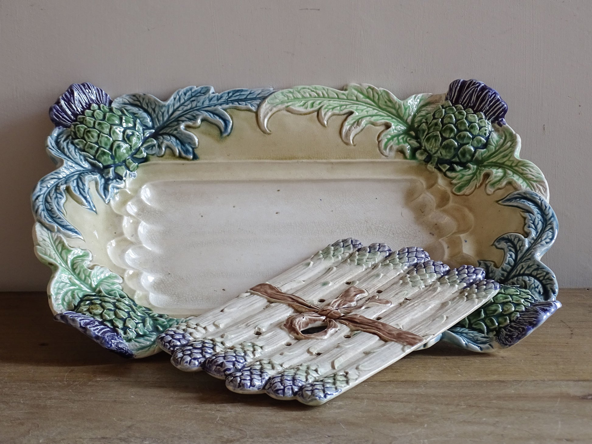 Antique French ceramic asparagus server with original draining tray modelled as tied asparagus spears.
