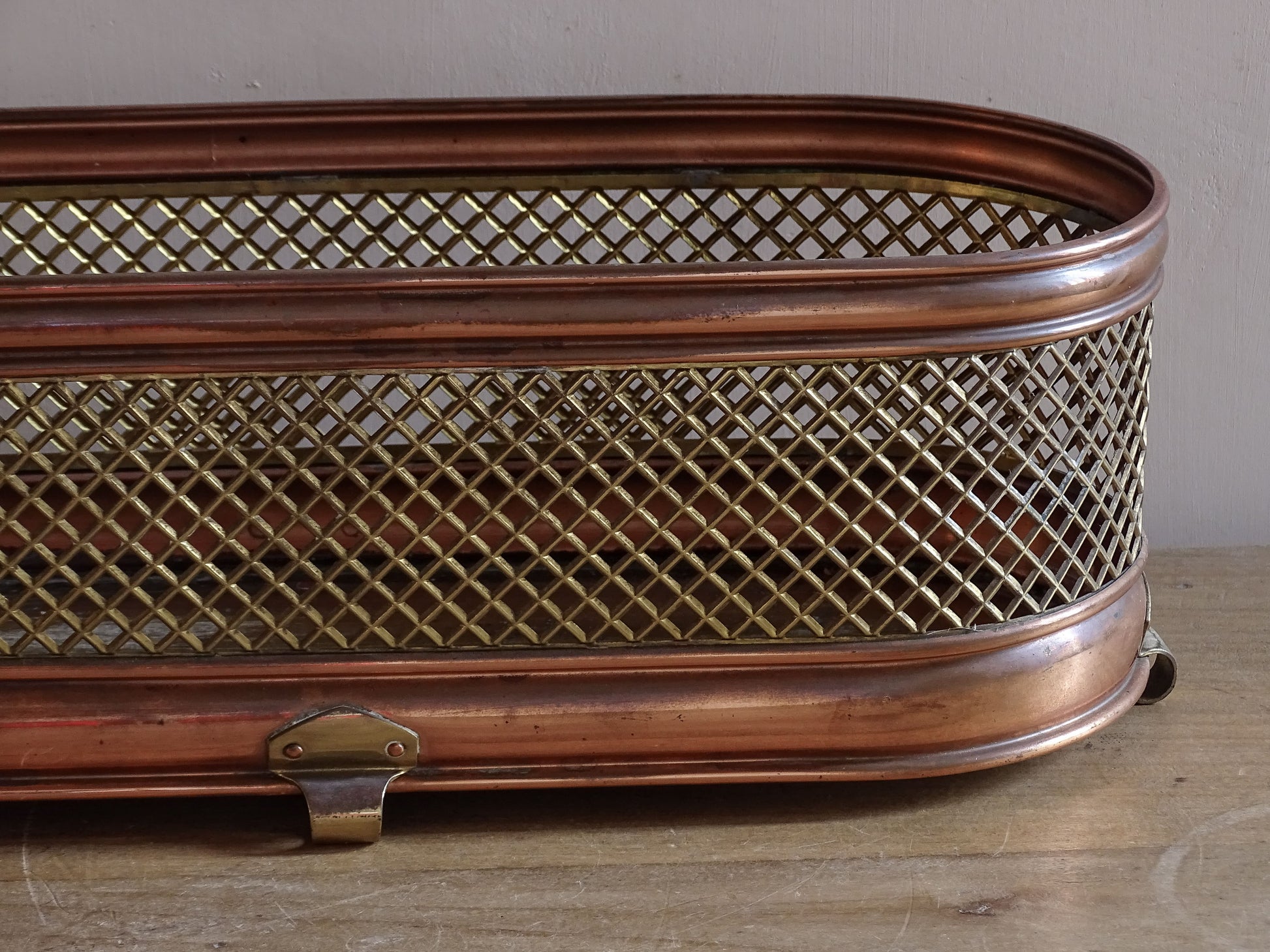 Decorative vintage metal planter with latticework sides and brass interior