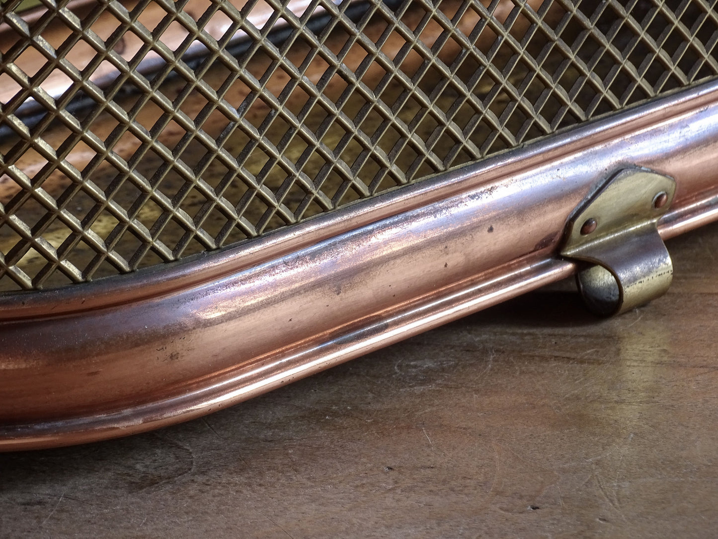 Brass and copper mesh cache pot displayed on a rustic wooden table