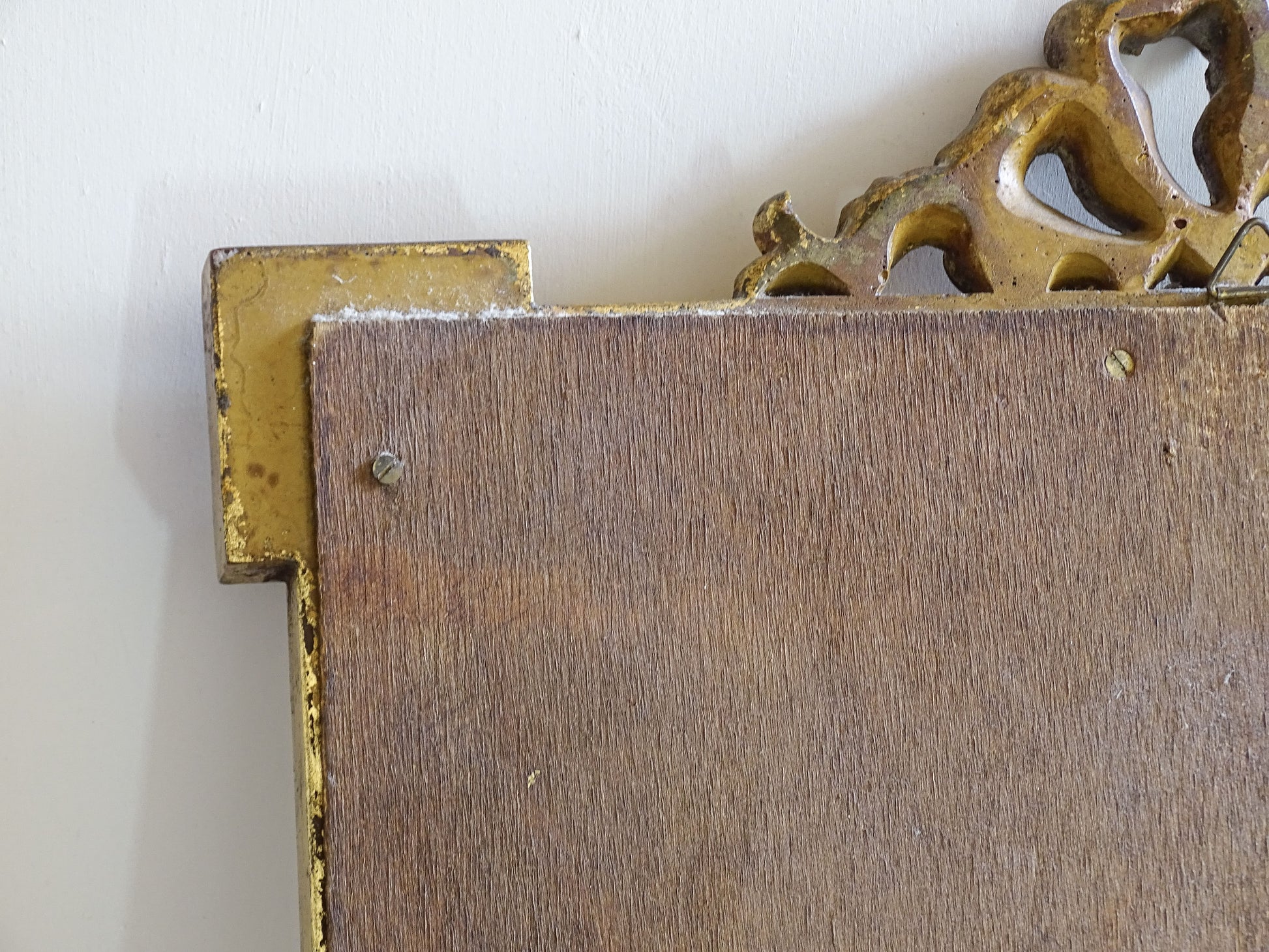 Full view of a French vintage gilt mirror with foxed glass and aged gilded finish
