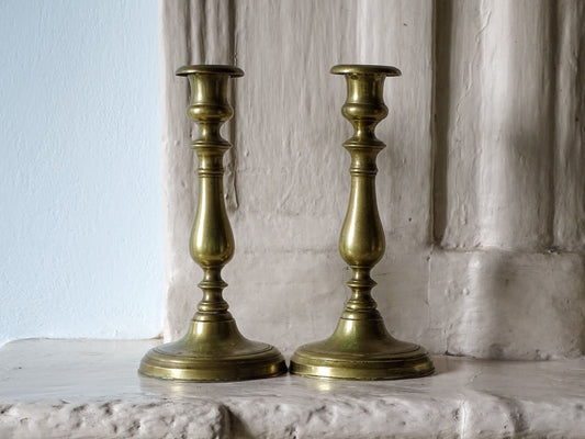 Pair of antique brass candlestick holders, pictured on a French country house fireplace